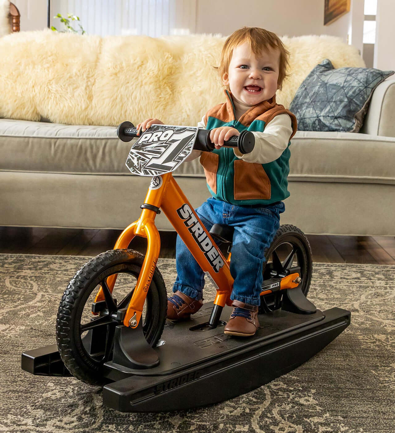 Smiling child riding the Strider Pro 2-in-1 Rocking Bike on its detachable rocking base.