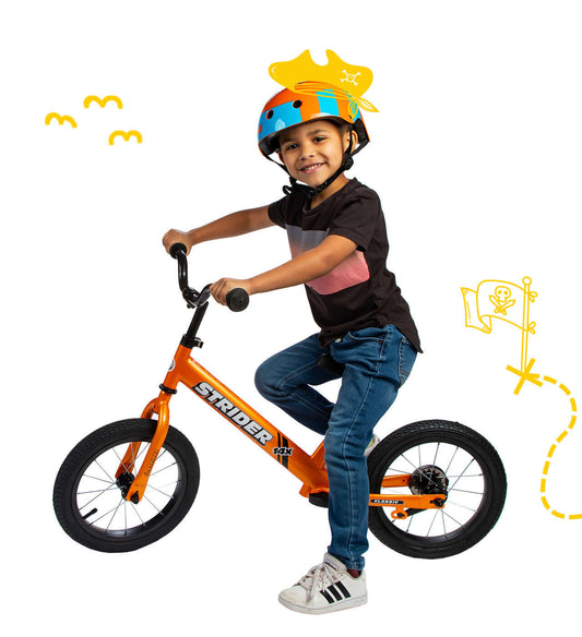 Child riding a Strider 14x Convertible Bike, wearing a colorful helmet, showcasing fun and learning in cycling.