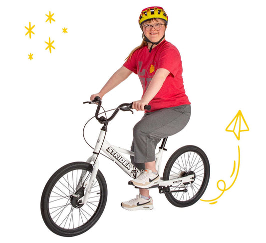 Girl riding a Strider 20x convertible bike, showcasing balance and fun for all ages.