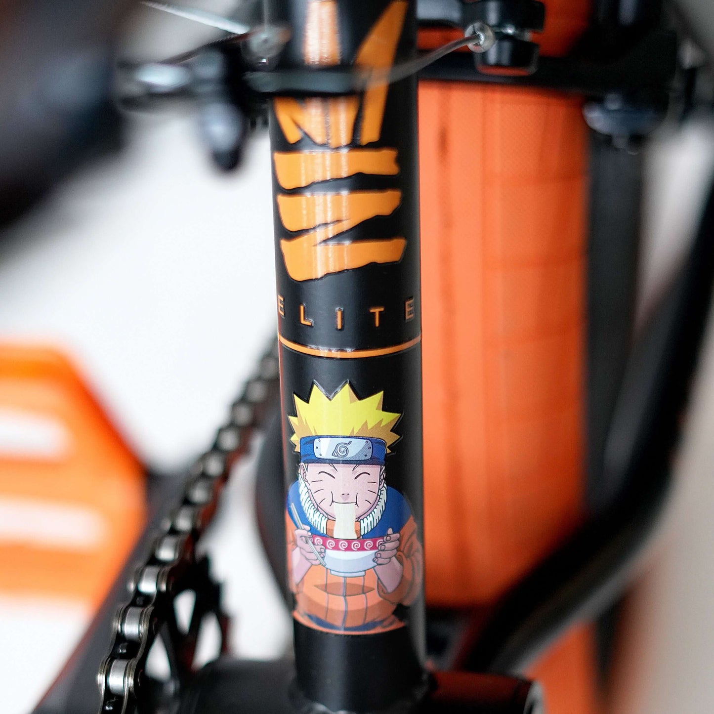 Close-up of the Elite BMX bike frame showcasing Naruto graphic design and iconic colors.