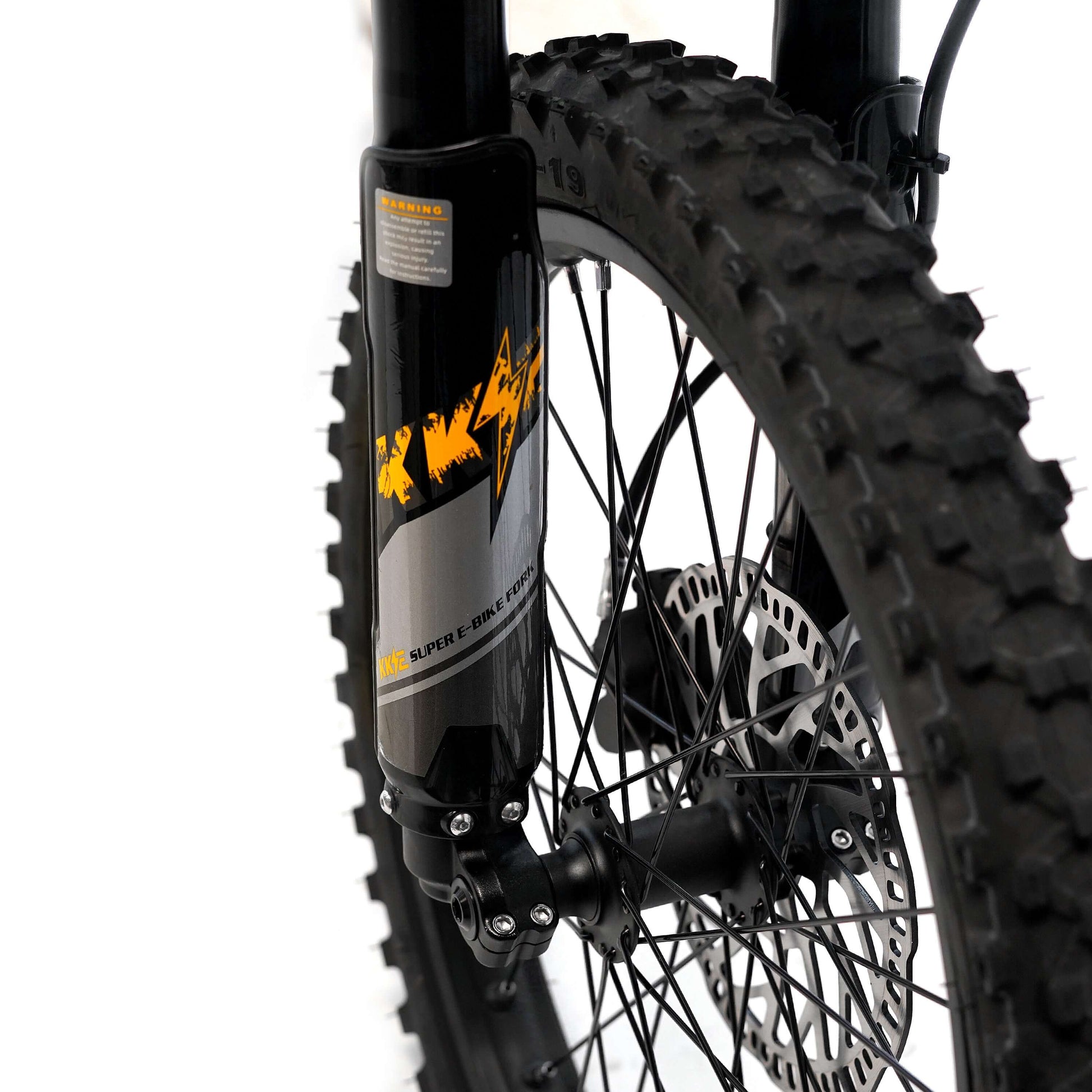 Close-up of Throne SRPNT e-DIRT BIKE front fork with rugged tire, showcasing detailed suspension and brake components.