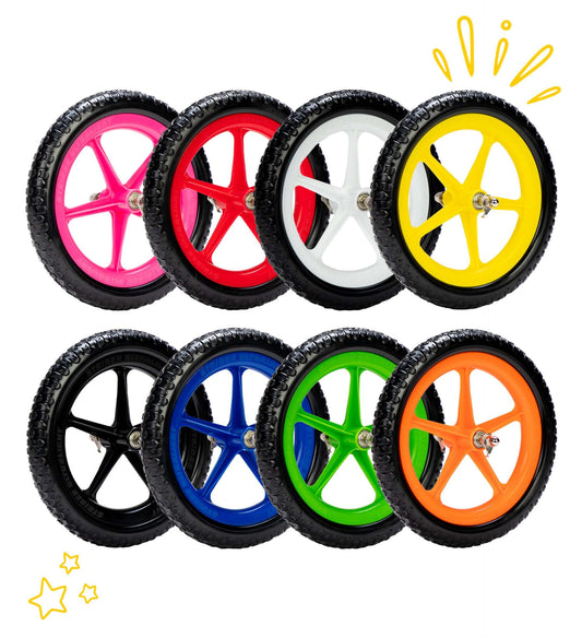 Colorful Strider Ultralight Wheels for balance bikes in pink, red, white, yellow, blue, green, and orange.
