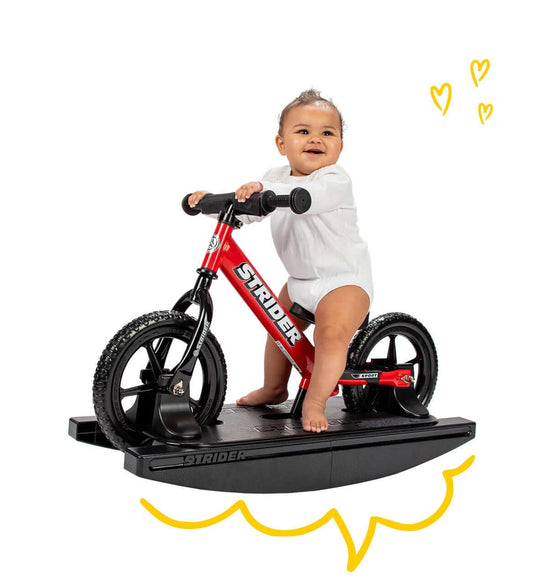 Baby enjoying playtime on Strider Balance Bike with Rocking Base, promoting early balance and confidence.
