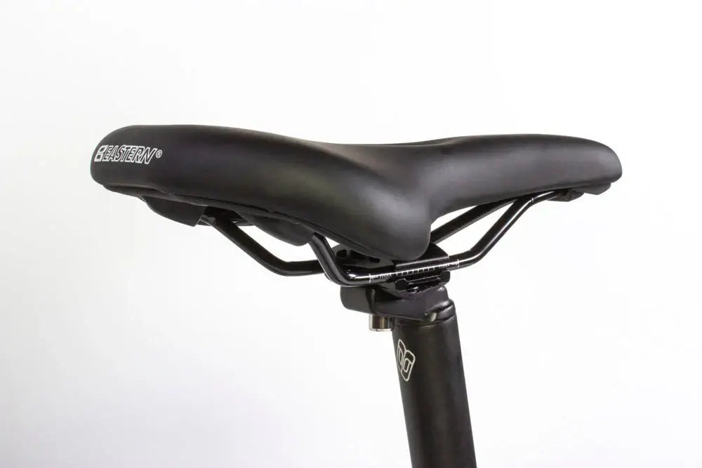 Close-up of a black bike saddle mounted on a seat post, designed for comfort and performance on various terrains.