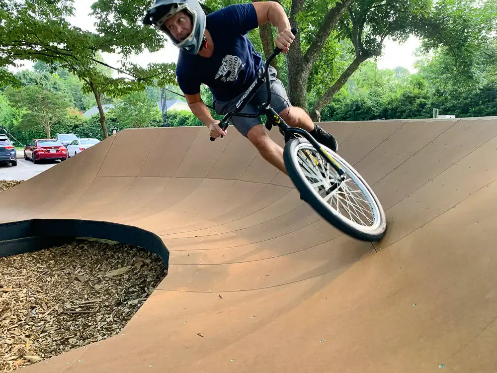 Rider performing a sharp turn on an Eastern Bike Big Reaper LTD on a smooth wooden ramp.
