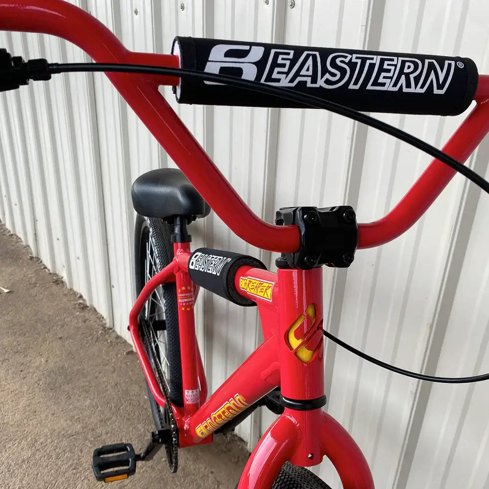Close-up of Eastern Bike Big Reaper LTD handlebars and grips, featuring Eastern branding on a vibrant red frame.