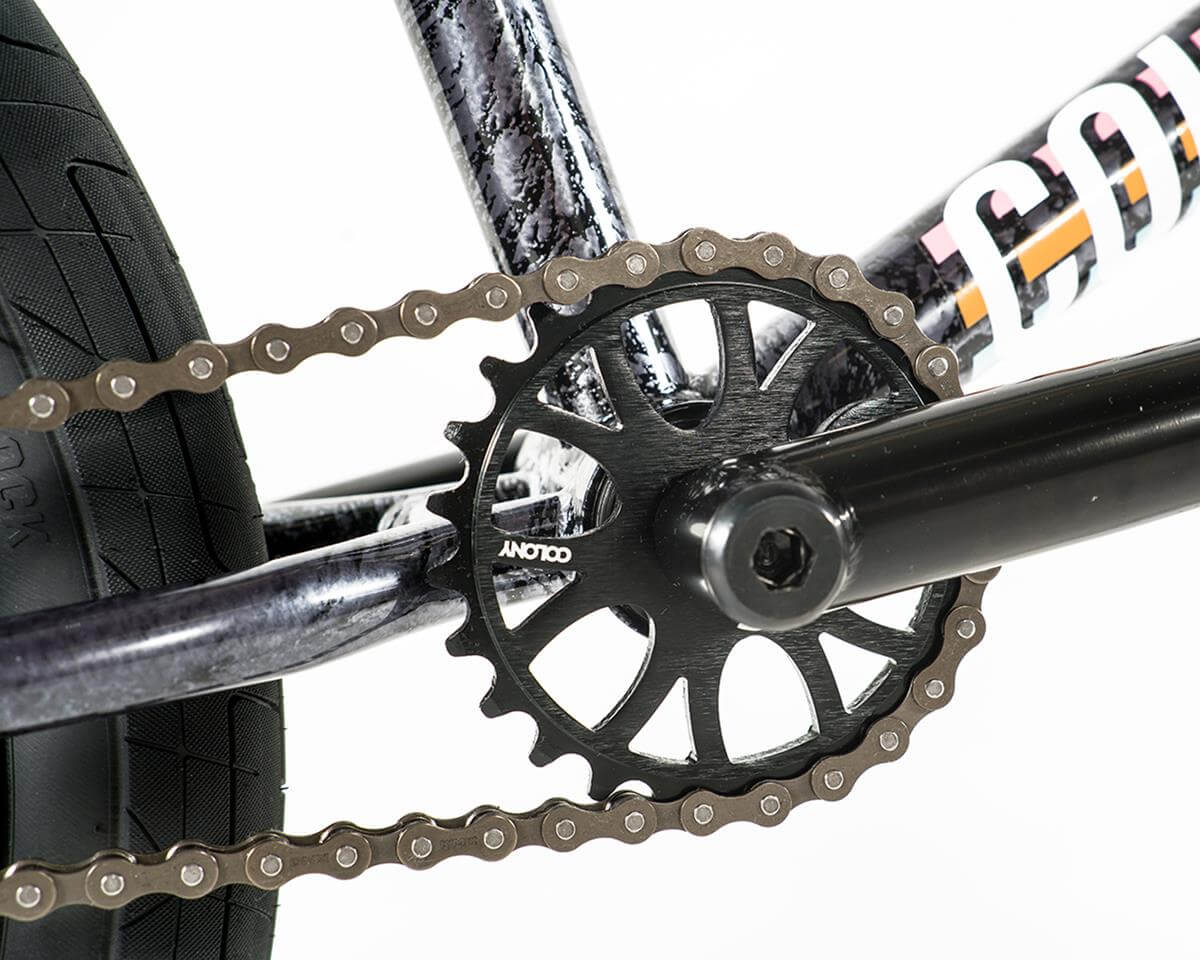 Close-up of the Colony Premise BMX bike's black sprocket and chain with a full chromoly frame.