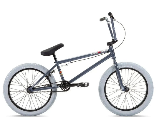 Stolen Heist 20" BMX bike in gray with white tires, featuring durable chromoly frame and aftermarket parts.