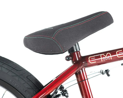 Close-up of the Colony Emerge BMX bike seat, featuring a textured black cover and red stitching for enhanced grip.